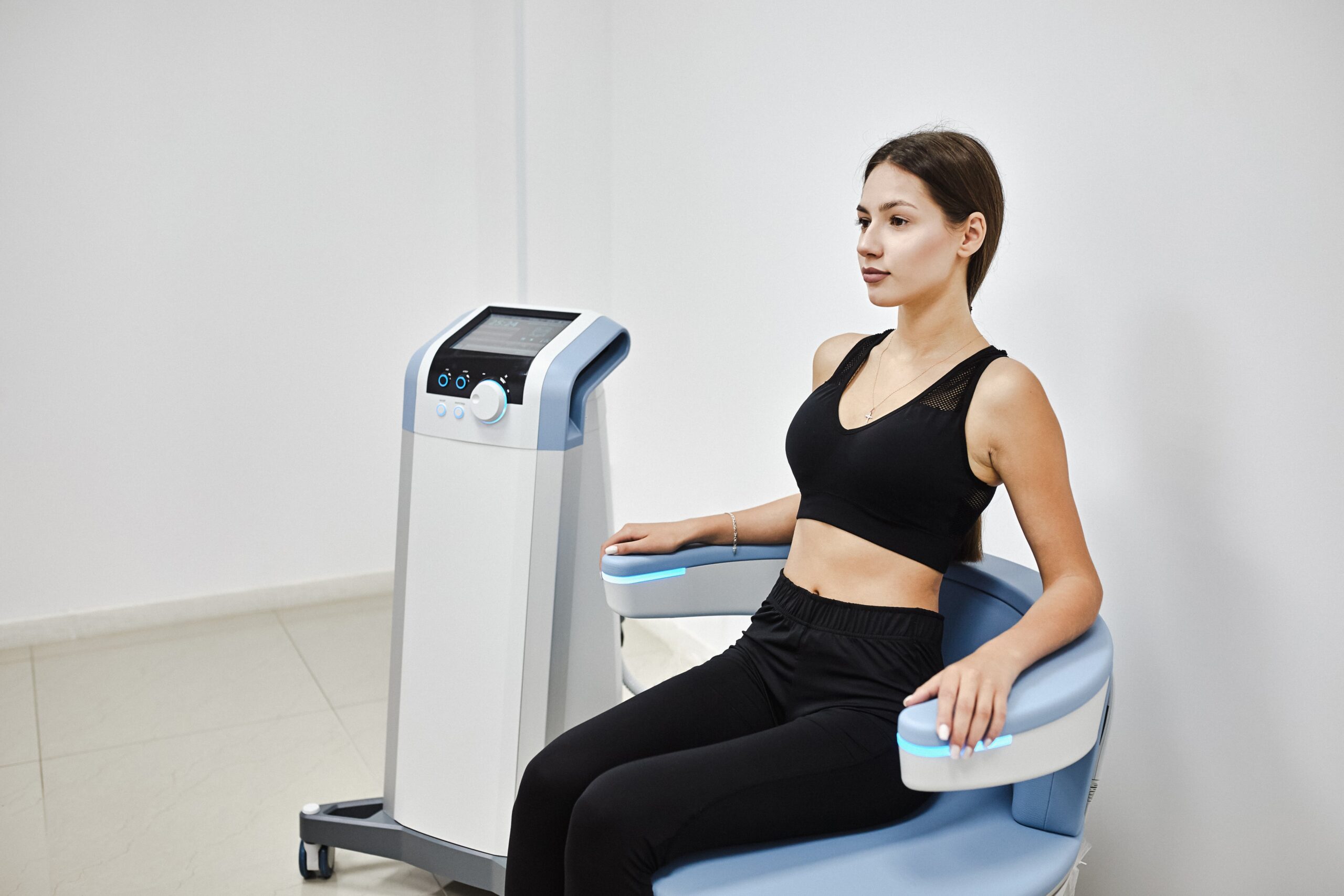 10 Signs You Might Need Pelvic Floor Strengthening and How Emsella Can Help 1 Young woman sitting on electromagnetic chair for stimulation of deep pelvic floor muscles
