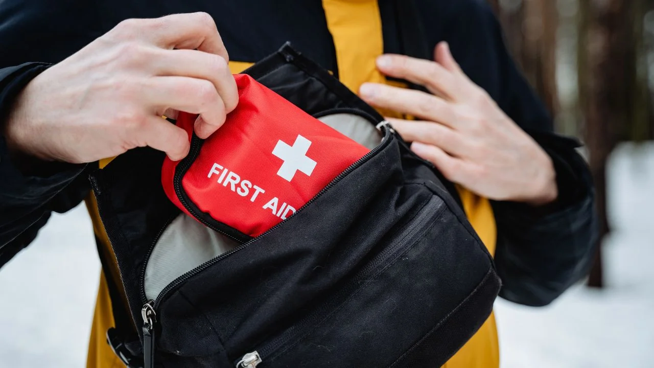 person is currently holding a small first aid kit